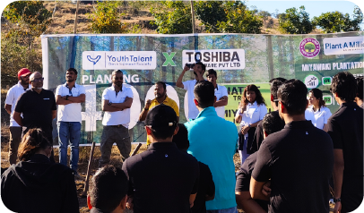 Toshiba and YTDS team gathered near plantation banner during drive 